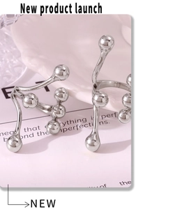 Artistic silver bead molecular open ring set on a minimal ceramic dish display