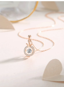 Detail of rose gold crown necklace with a dancing stone pendant in macro photography