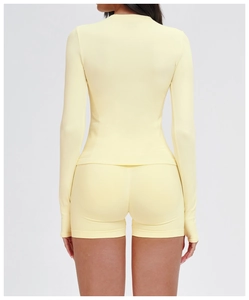 Detail von hellgelbem nahtlosem Langarm-Yoga-Top und High-Waist-Shorts mit Strickstruktur