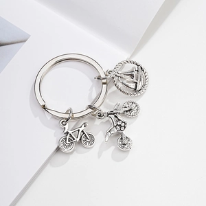 Vintage silver metal keychain featuring detailed sailboat, bicycle, and motorcycle charms
