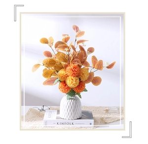 Artistic floral arrangement with eucalyptus and yellow pompon mummies in a ceramic vase