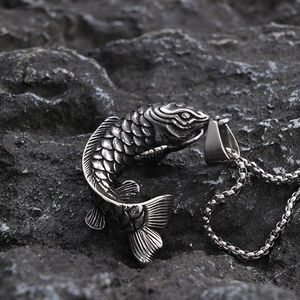 Macro shot of silver koi fish pendant with vintage texture and detailed fish scales