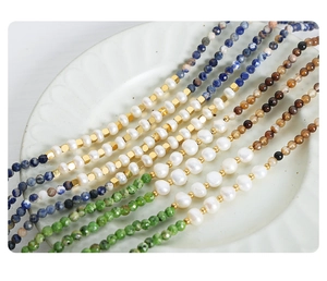 Detailed close-up of colorful natural stones and freshwater pearl necklaces on a plate