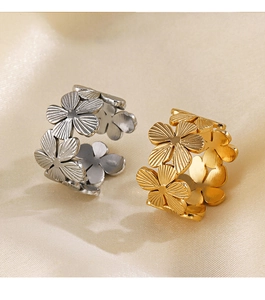 Vue détaillée de deux bagues fleurs en or et argent posées sur un tissu satiné