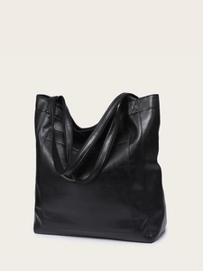 Détail de vue latérale d'un grand sac cabas en cuir ciré noir avec des poignées robustes