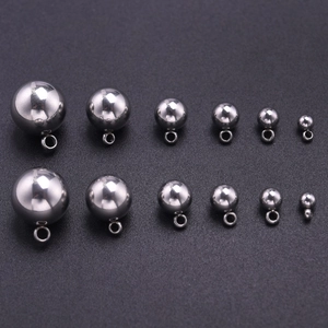 Vue macro de différentes tailles de pendentifs sphériques en acier inoxydable poli avec anneaux