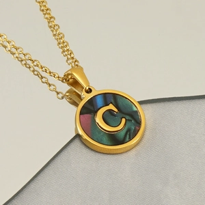 Détail d'un collier doré en acier inoxydable avec pendentif rond lettre C nacré