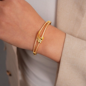 Detailed view of an 18k gold plated double layer bangle with sparkling cubic zirconia pavé