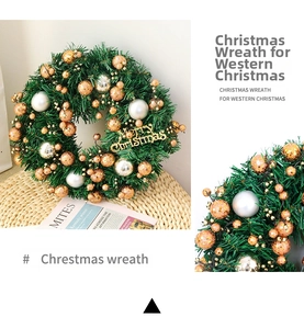 Detailed close-up of artificial Christmas wreath with gold ornaments and pine needles