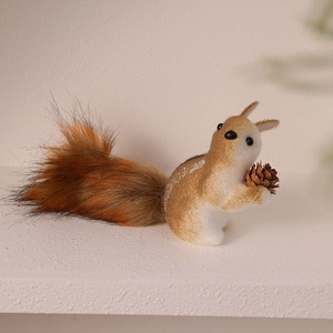 Detailed close-up of a foam squirrel ornament with fluffy fur tail and real pinecone