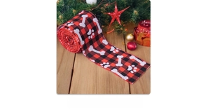 Close-up of buffalo plaid Christmas ribbon with white dog paw and bone prints for DIY gifts