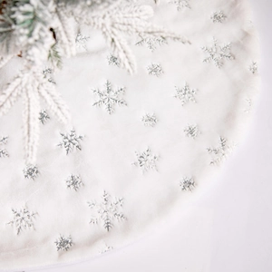 White plush Christmas tree skirt with silver sequin snowflakes for festive holiday decor