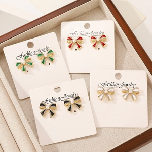 Vintage French bow earrings with pearls and rhinestones in four colors on a jewelry tray