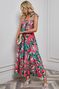 Detail of floral print maxi dress featuring backless strap design and layered cake skirt
