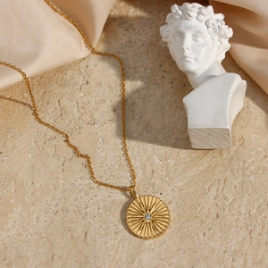 Detail of 18K gold-plated star pendant necklace with crystal on silk and marble base