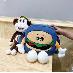 Detail of blue canvas burger bag with 3D plush arms and legs on wooden surface
