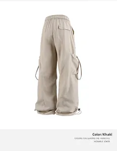 Dettaglio dei pantaloni cargo kaki con coulisse elastica e tasche laterali a patta
