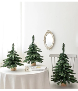 Close-up of mini Christmas trees with wooden bases on a white table for festive decor