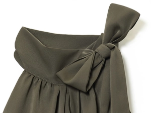 Detail of dark olive green halter top with delicate bow tie and pleated fabric texture