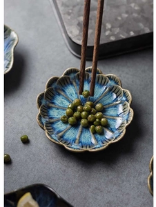 Macro shot of petal-shaped ceramic sauce dish with blue and brown reactive glaze finish