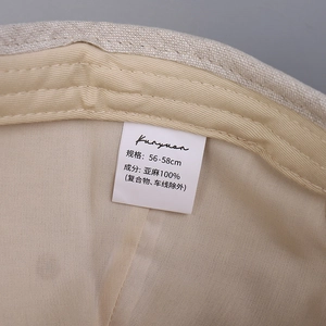 Linen baseball cap interior detail showing a white wash label and size 56-58cm specifications