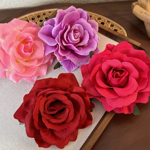 Detailed macro view of multi-color fabric rose hair clips with realistic layered silk petals
