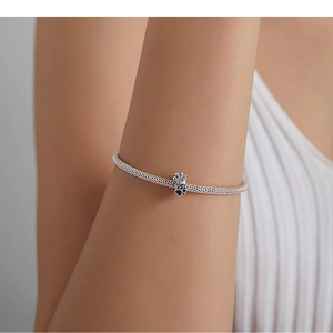 Detailed view of an S925 silver mesh bracelet with a sparkling cat paw charm on wrist