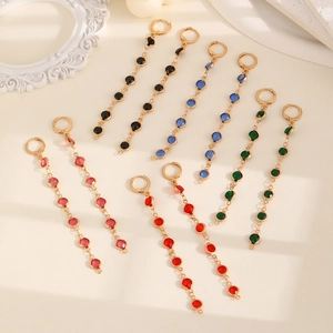 Detail view of long tassel earrings with colorful glass gemstones and gold plated copper chain