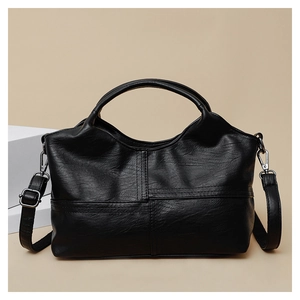 Detail of soft black PU leather tote with adjustable strap and silver metal hardware