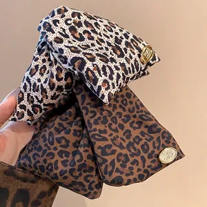 Vintage leopard print hair clip with gold metal tag and high-end aesthetic