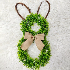 Easter bunny wreath with green leaves and vine ears on a soft white plush background
