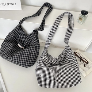 Detail of minimalist plaid tote bags with woven label and wide shoulder straps