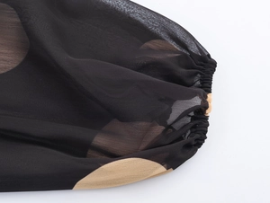 Détail des poignets élastiques et du tissu en mousseline à pois sur la robe