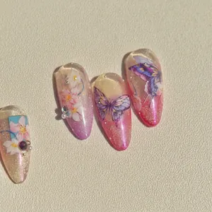 Faux ongles amande avec papillons violets, motifs floraux et décoration en strass