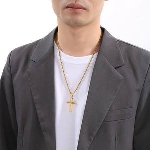 Polished gold cross pendant necklace on male model with twist chain detail