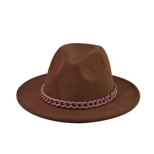 Détail d'un chapeau fedora en laine marron foncé avec une grosse chaîne décorative rose