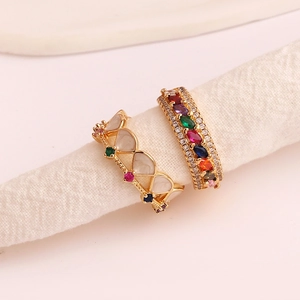 Close-up of gold hollow geometric rings with colorful marquise stones and zircons