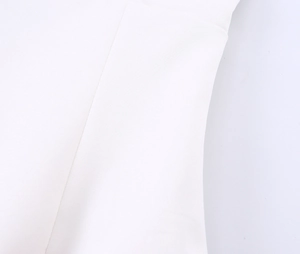 Detailopname van de witte stofstiksels en afwerkingskwaliteit van de modieuze camisole