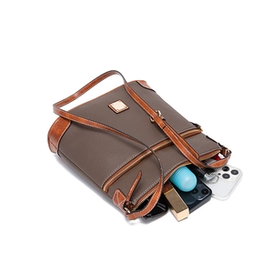 Close-up of brown pebbled leather crossbody bag showing interior storage and gold zipper