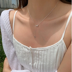 Macro shot of minimalist 925 sterling silver water drop necklace on a female model