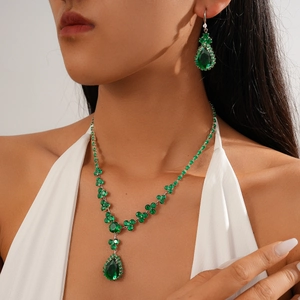 Close-up of a model wearing a green teardrop zircon necklace and matching earrings