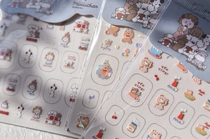 Detail view of embossed cartoon dog and bear nail art stickers with 3D relief texture