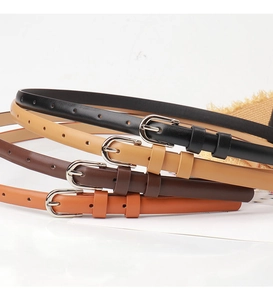 Detailed view of four narrow leather belts in black and brown shades with alloy buckles