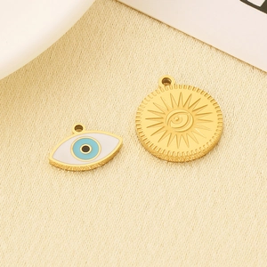 Macro detail of 18K gold evil eye charms and embossed medallion for jewelry making
