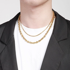 Gros plan d'un collier hip hop doré double épaisseur pour homme avec veste noire
