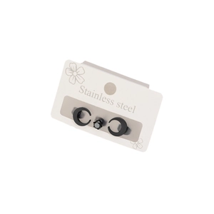 Set of three black stainless steel crescent moon and zircon stud earrings on display