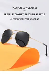 Fashion aviator sunglasses with gold metal frames and dark lenses on creative orange backdrop