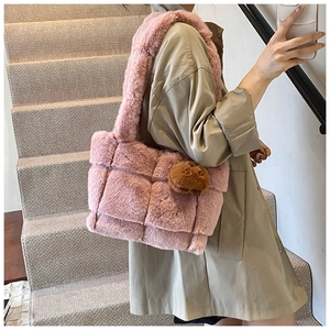 Detail of pink faux fur woven tote bag with matching plush handle and decorative charm