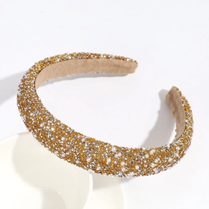 Detailed view of padded headband with golden rhinestones and white faux pearls