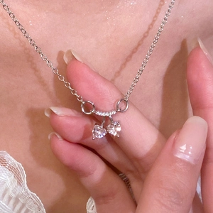 Detalle del collar de cereza en forma de corazón con circonitas claras en el modelo